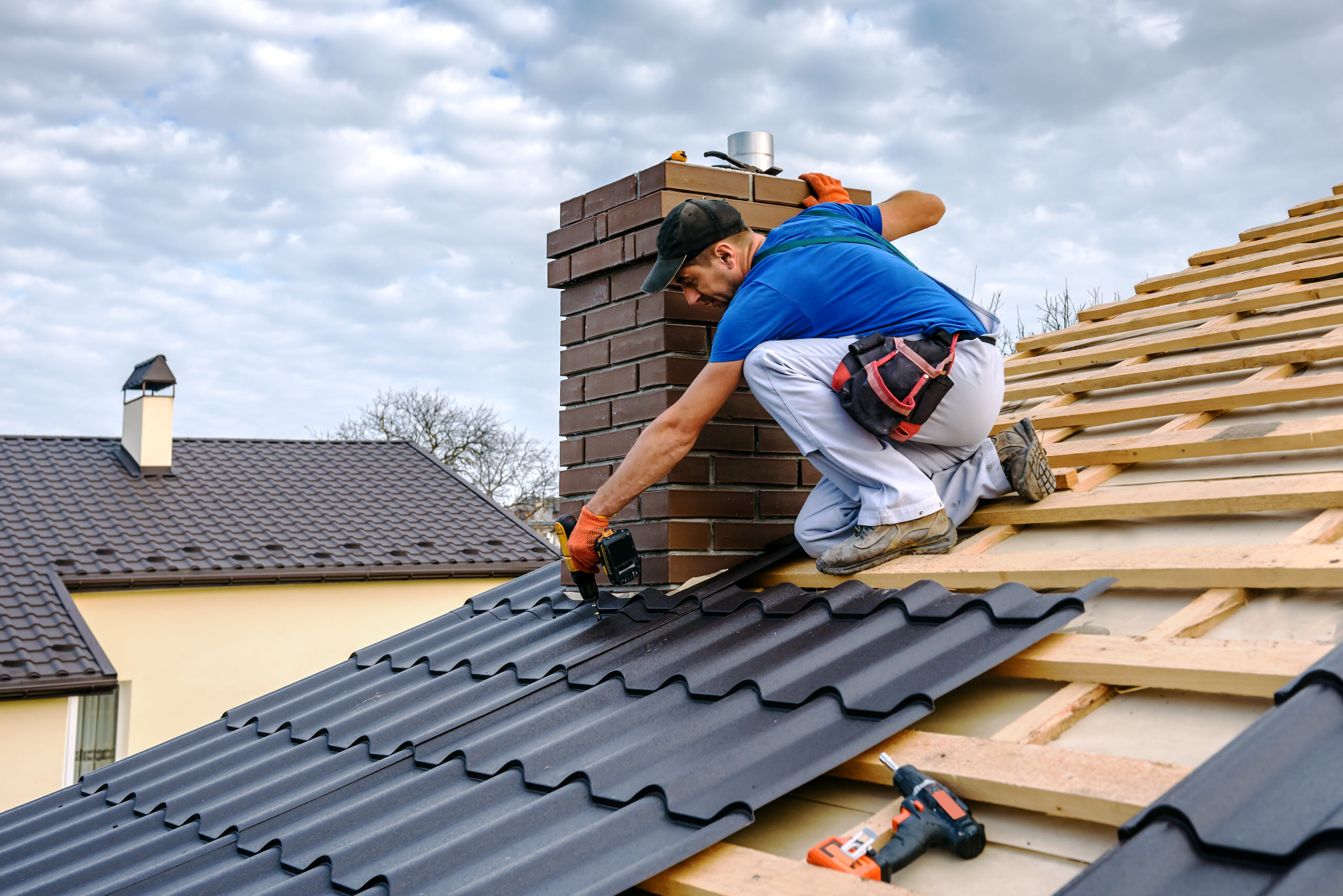 A professional master roofer with electric screwdriver