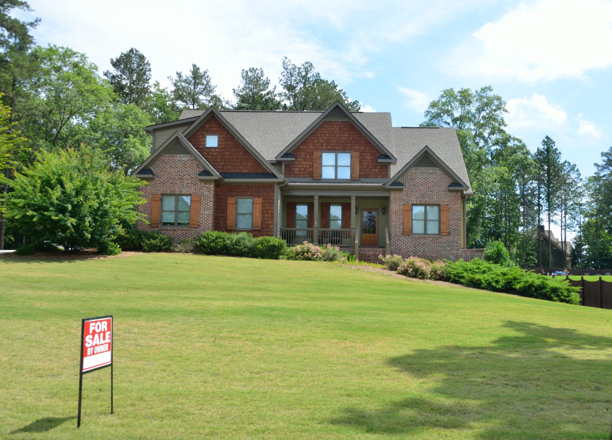 Beautiful home with for sale signage in the front yard
